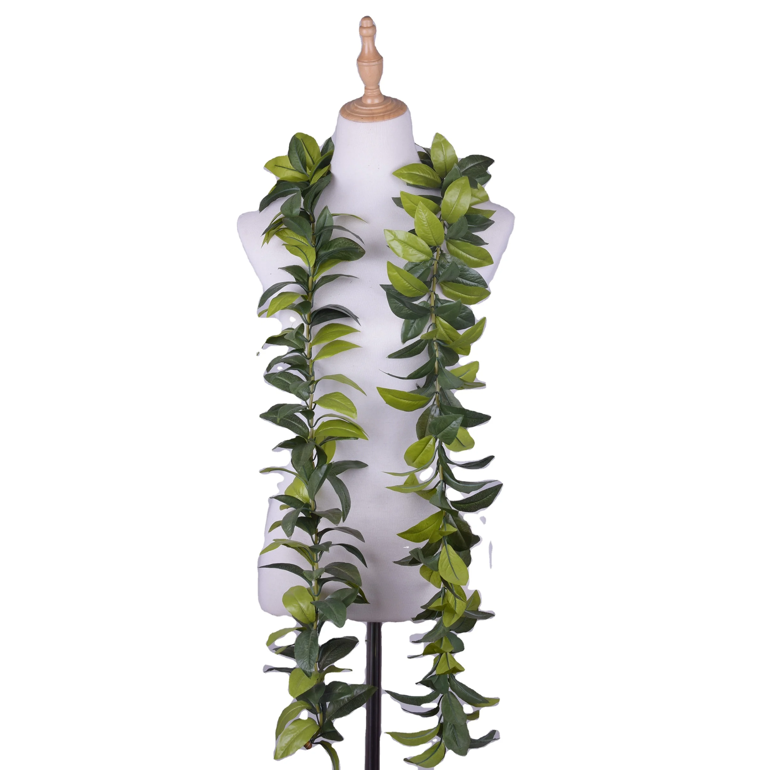 Mannequin bust displaying long green leaf garlands draped around the neck like a lei, white background, natural green tones