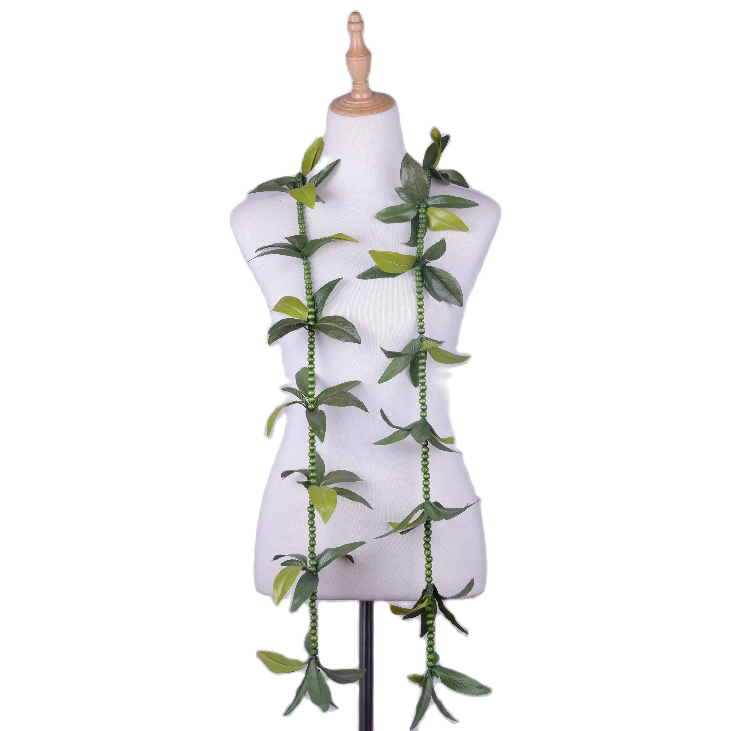 Mannequin bust displaying long green leaf and bead garlands draped around the neck, white background, green tones